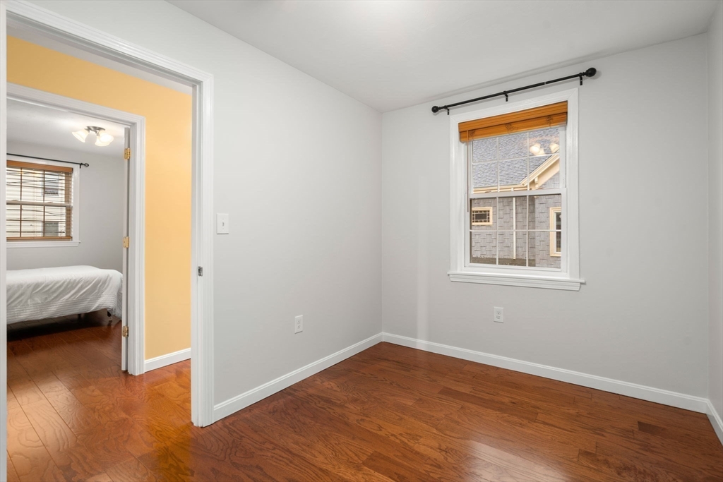 104 Crescent Street, Unit 1 Waltham, MA 02453 - Photo 22 of 30 a view of empty room with wooden floor and fan
