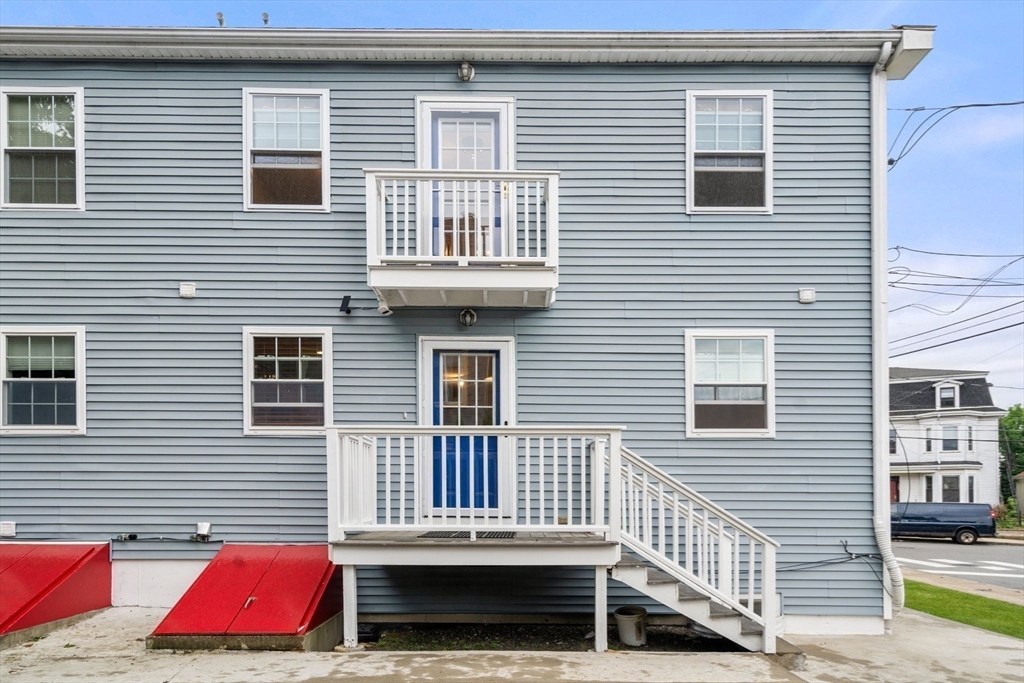 104 Crescent Street, Unit 1 Waltham, MA 02453 - Photo 28 of 30 a view of a house with a door and wooden fence
