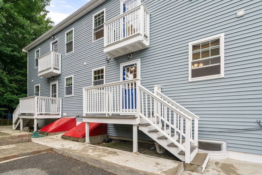 104 Crescent Street, Unit 1 Waltham, MA 02453 - Photo 29 of 30 a view of balcony with table and chairs and wooden fence