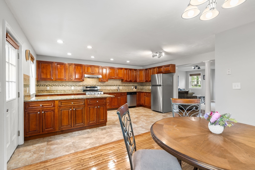 104 Crescent Street, Unit 1 Waltham, MA 02453 - Photo 7 of 30 a kitchen with stainless steel appliances granite countertop a sink and cabinets