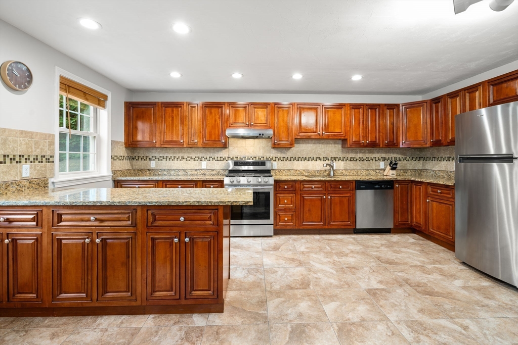 104 Crescent Street, Unit 1 Waltham, MA 02453 - Photo 8 of 30 a kitchen with stainless steel appliances granite countertop a stove top oven sink and cabinets