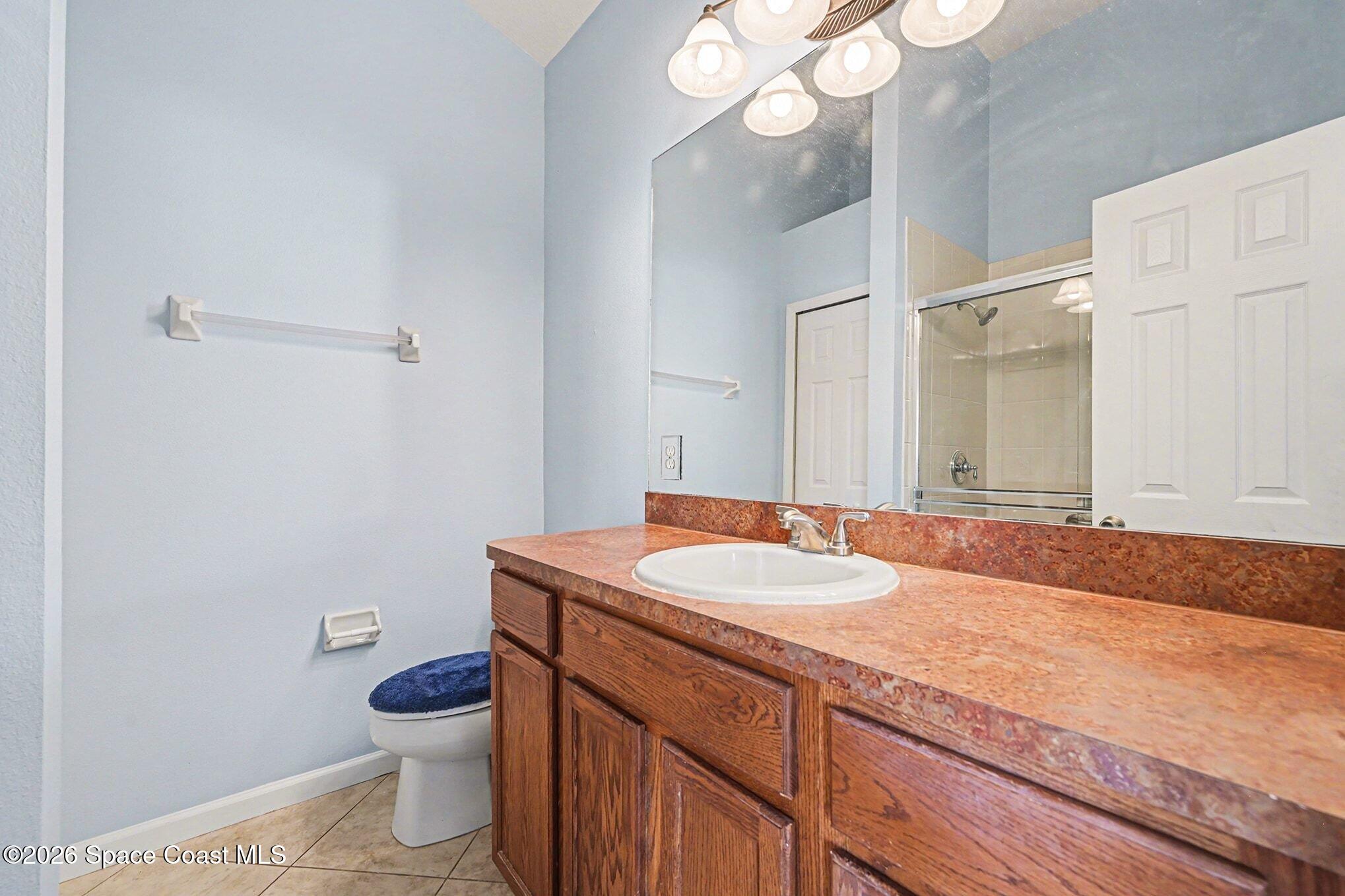 3271 Arden Circle Melbourne, FL 32934 - Photo 16 of 29 a bathroom with a granite countertop sink a toilet and a mirror