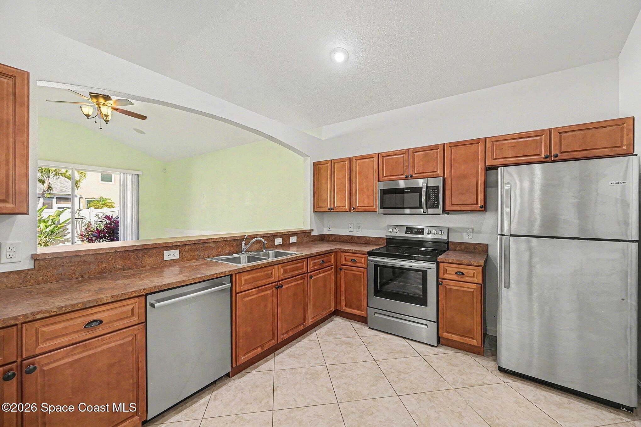 3271 Arden Circle Melbourne, FL 32934 - Photo 18 of 29 a kitchen with stainless steel appliances granite countertop a refrigerator sink and stove