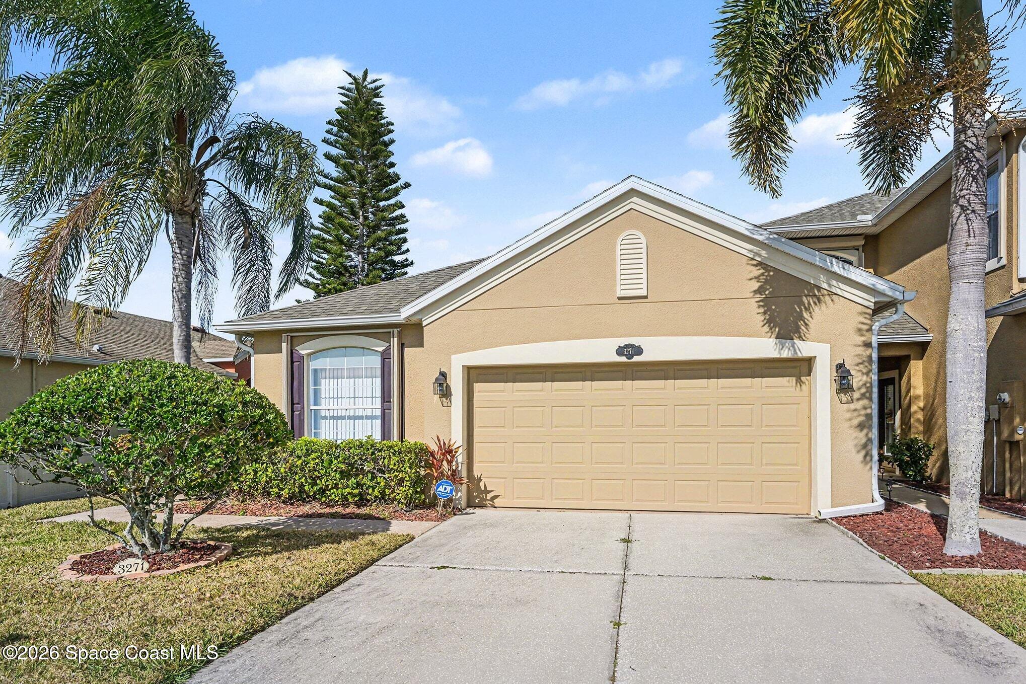 3271 Arden Circle Melbourne, FL 32934 - Photo 2 of 29 a front view of a house with a yard and garage