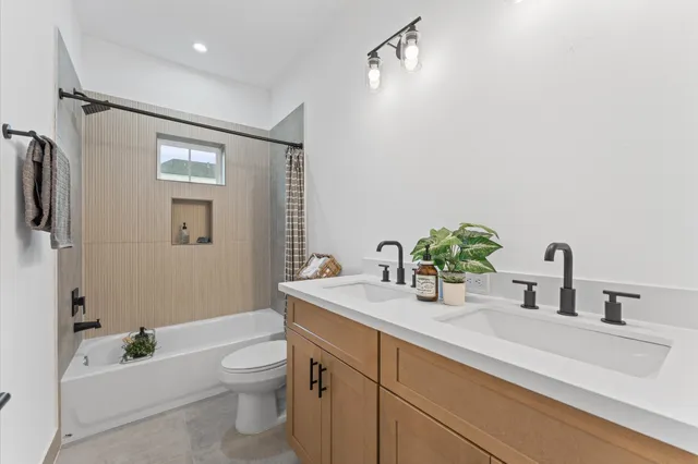 a bathroom with a granite countertop sink a toilet a mirror and shower