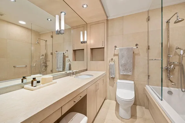 a bathroom with a sink a toilet and shower