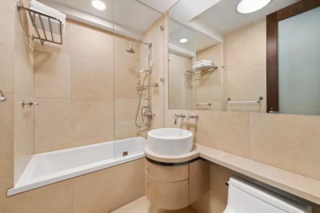 a bathroom with a sink a toilet and shower