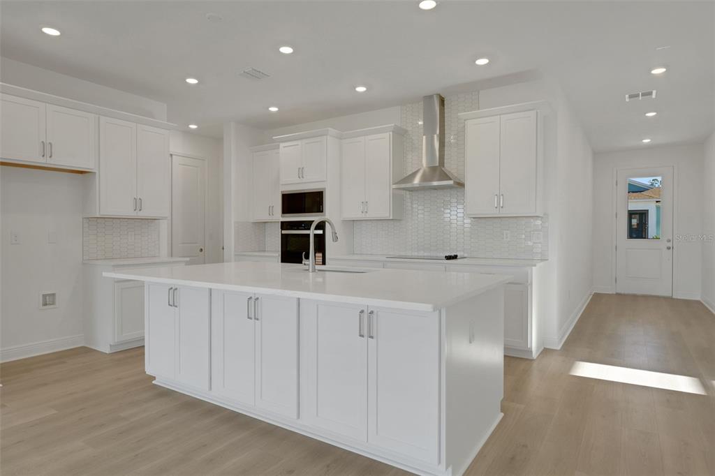 994 Fiesta Key Circle Lady Lake, FL 32159 - Photo 11 of 49 a kitchen with white cabinets stainless steel appliances and sink