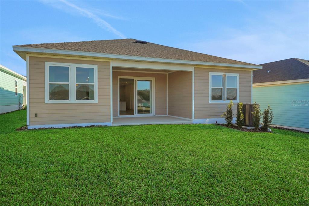 994 Fiesta Key Circle Lady Lake, FL 32159 - Photo 6 of 49 a view of a house with backyard porch and garden