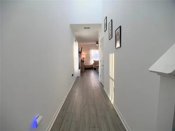 a view of a hallway with wooden floor and staircase