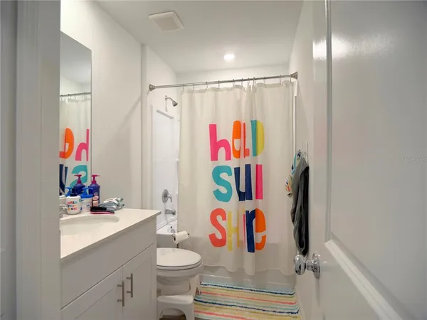 a bathroom with a sink toilet and shower curtain