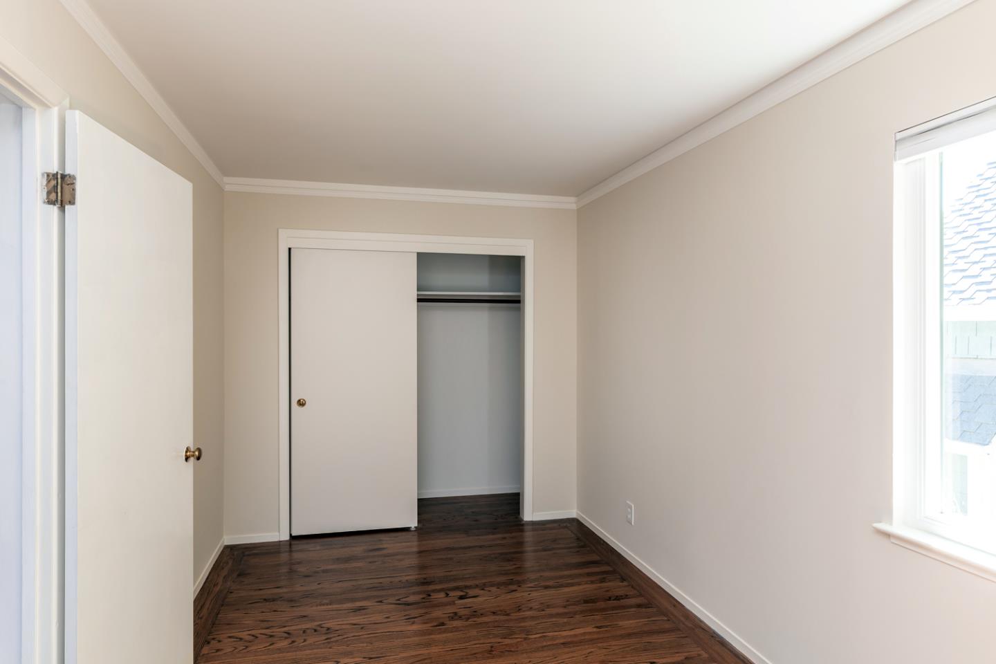 425 Hillcrest Road San Mateo, CA 94402 - Photo 30 of 48 a view of an empty room with wooden floor and a window