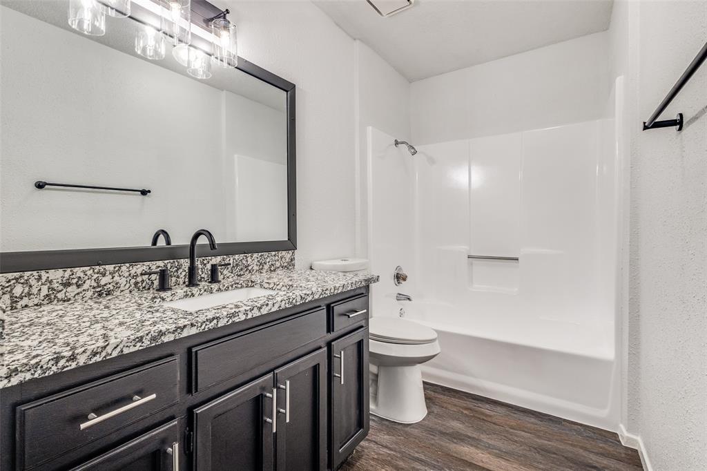 3326 Gardenview Circle Denton, TX 76207 - Photo 11 of 13 a bathroom with a granite countertop toilet sink and mirror