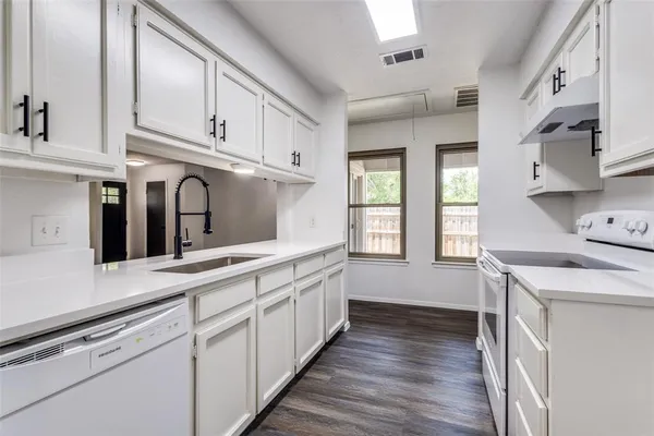 a kitchen with granite countertop white cabinets and white appliances