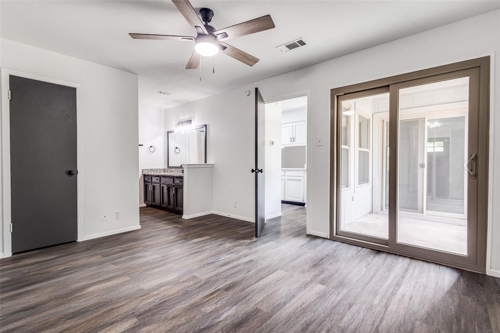 3326 Gardenview Circle Denton, TX 76207 - Photo 7 of 13 a view of a big room with wooden floor a ceiling fan and windows