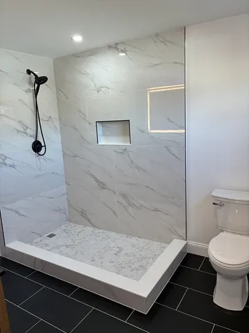 a bathroom with a granite countertop sink and toilet