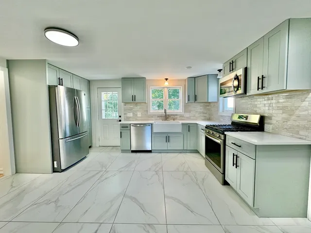 a kitchen with stainless steel appliances a refrigerator sink and cabinets