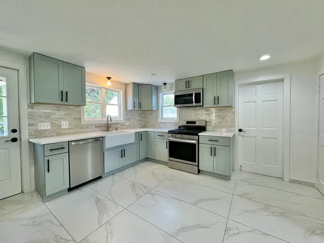 a kitchen with granite countertop a stove sink and cabinets