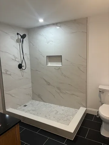 a bathroom with a granite countertop sink a toilet and shower