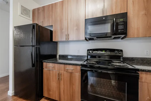 a kitchen with stainless steel appliances granite countertop a stove microwave refrigerator and sink