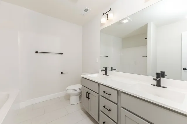 a bathroom with a sink a toilet and a mirror