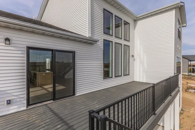 a view of a house with deck and floor to ceiling window