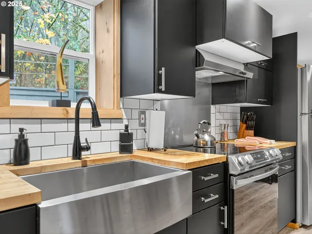 a kitchen with a sink and a stove next to a window