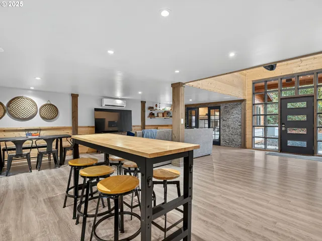 a kitchen with stainless steel appliances granite countertop a stove top oven a dining table and chairs with wooden floor