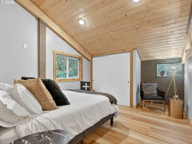 a bedroom with a bed a lamp and large windows