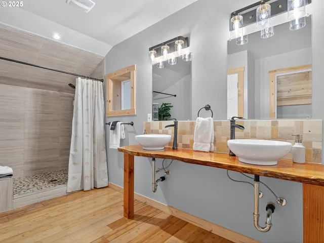 a spacious bathroom with a granite countertop sink a mirror and shower