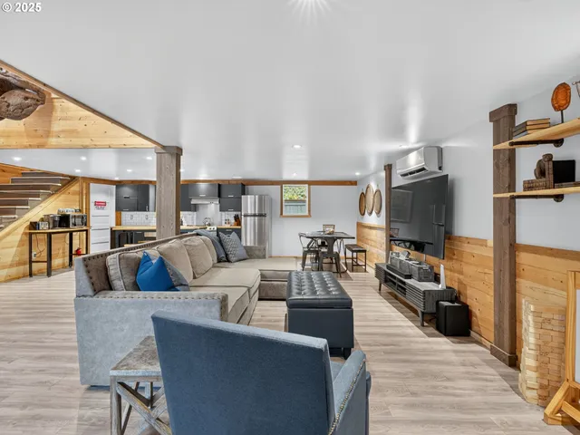 a living room with furniture kitchen view and a flat screen tv