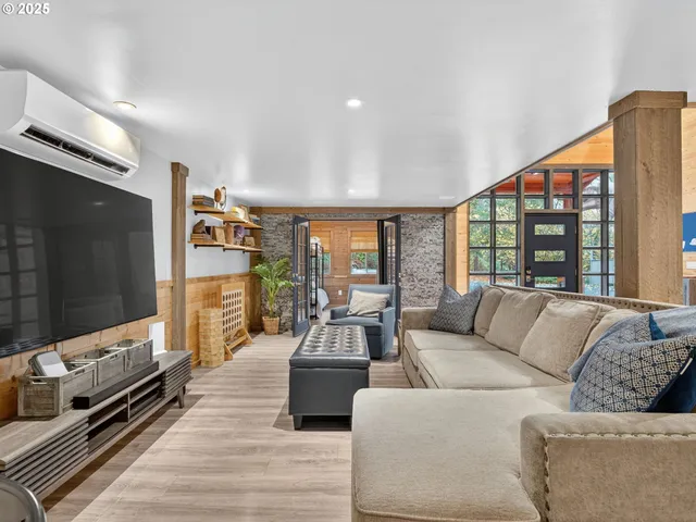 a living room with furniture flat screen tv and a large window