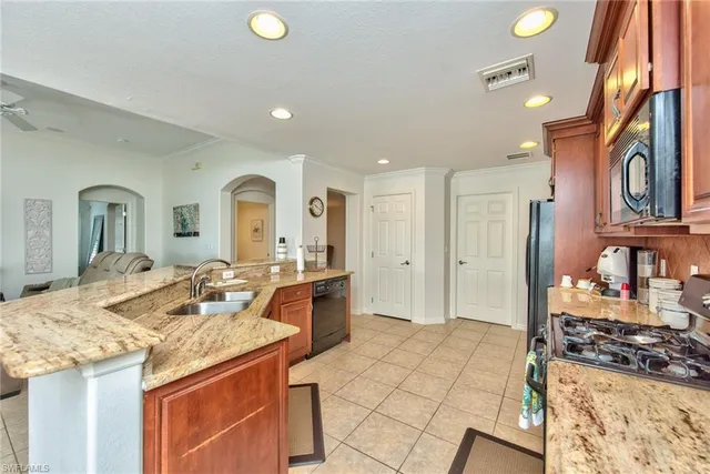 a large kitchen with stainless steel appliances granite countertop a sink and cabinets