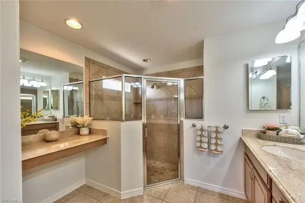 a bathroom with a double vanity sink mirror and shower