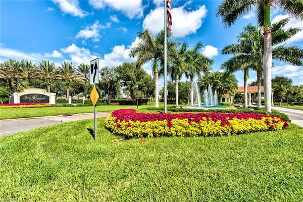 a view of a white house with a big yard and palm trees