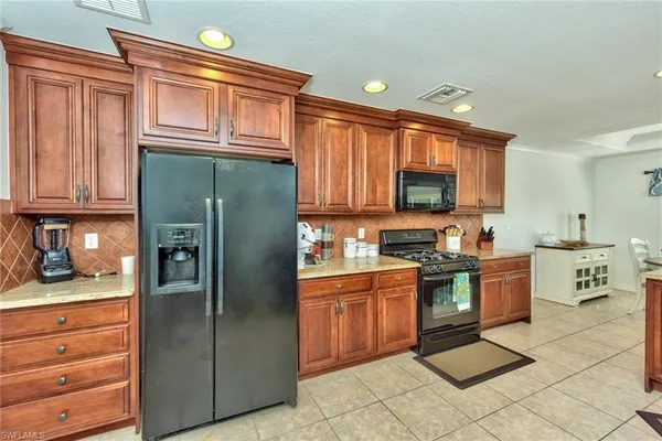 a kitchen with stainless steel appliances granite countertop a refrigerator stove and sink