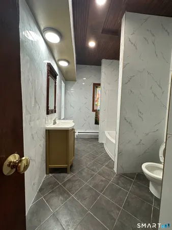 a bathroom with a sink a toilet and shower