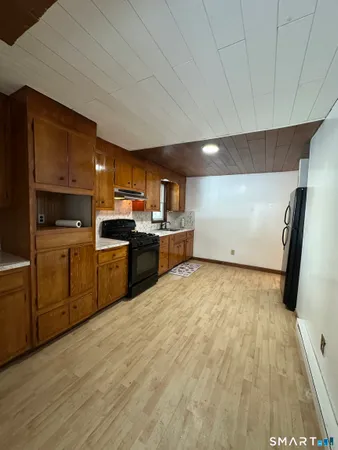 a kitchen with stainless steel appliances a sink a stove top oven a refrigerator and cabinets