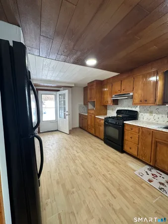 a kitchen with granite countertop a refrigerator stove and microwave