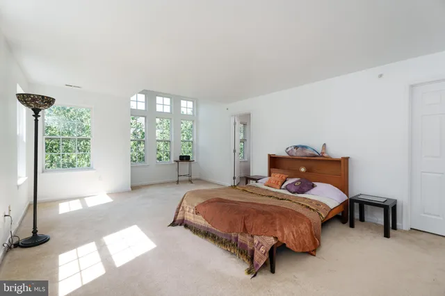 a bedroom with a bed and large window