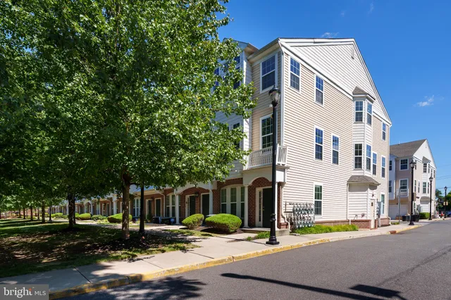 a view of a white building among the street with houses