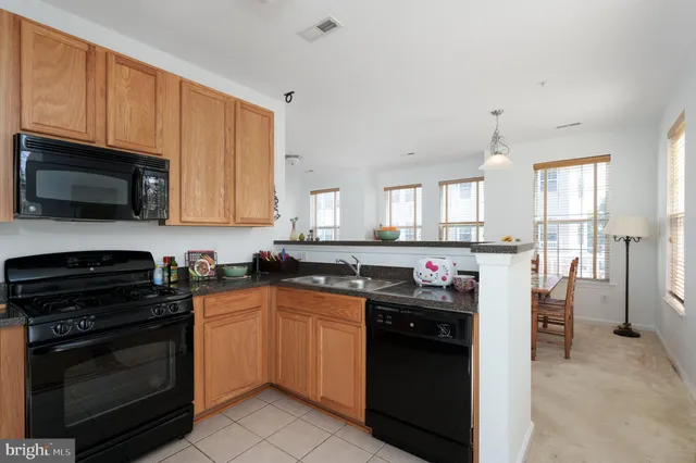 a kitchen with a sink stove top oven and refrigerator