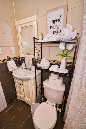 a bathroom with a toilet sink and mirror