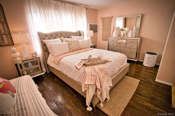 a bedroom with a bed a mirror and dresser