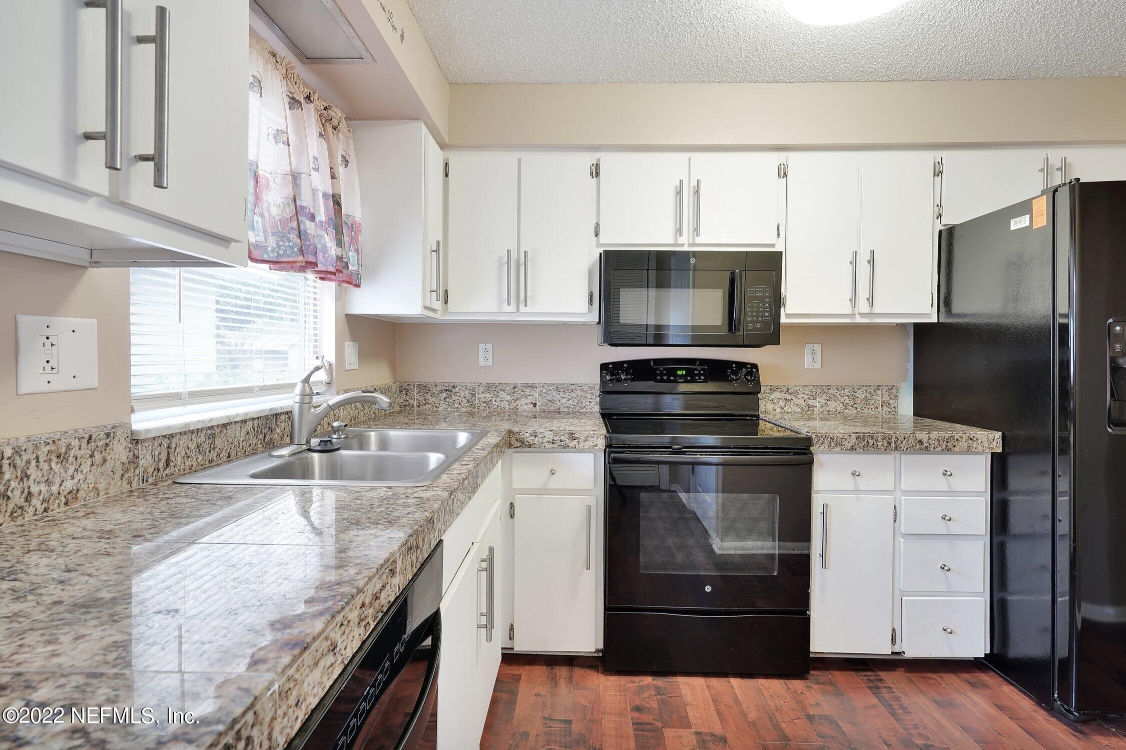 208 Baracoa Court St. Augustine, FL 32086 - Photo 17 of 32 a kitchen with granite countertop a sink stainless steel appliances and cabinets