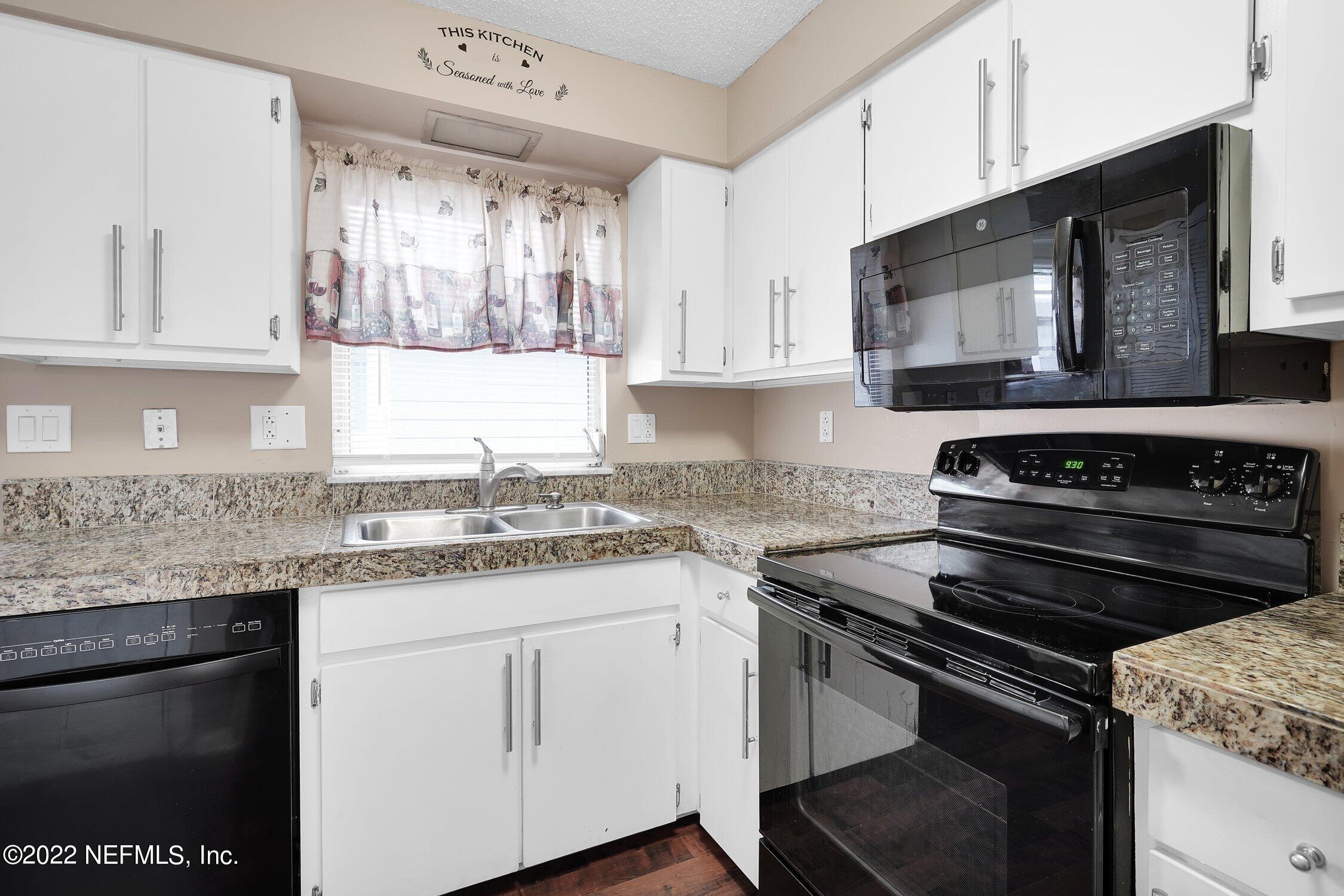 208 Baracoa Court St. Augustine, FL 32086 - Photo 18 of 32 a kitchen with a stove microwave and sink
