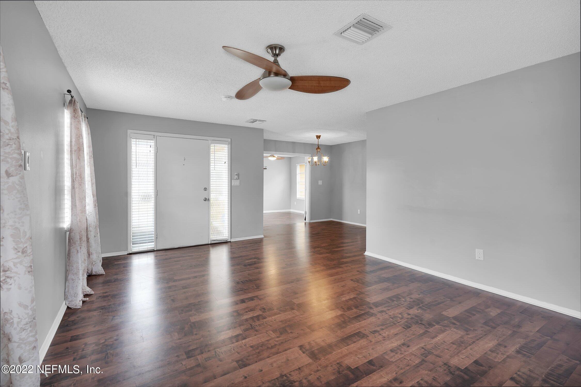 208 Baracoa Court St. Augustine, FL 32086 - Photo 7 of 32 a view of an empty room with wooden floor and a ceiling fan