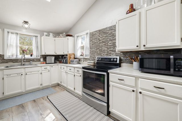 a kitchen with granite countertop white cabinets and white appliances