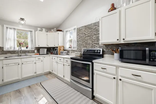 a kitchen with granite countertop white cabinets and white appliances