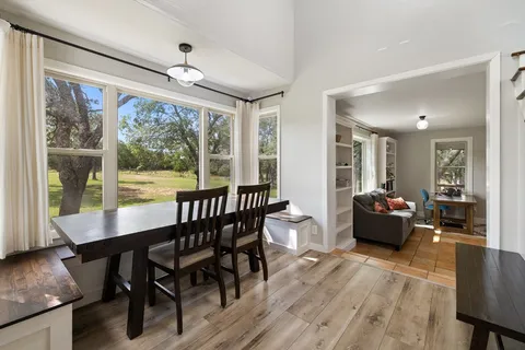 a view of a dining room with furniture large windows and wooden floor